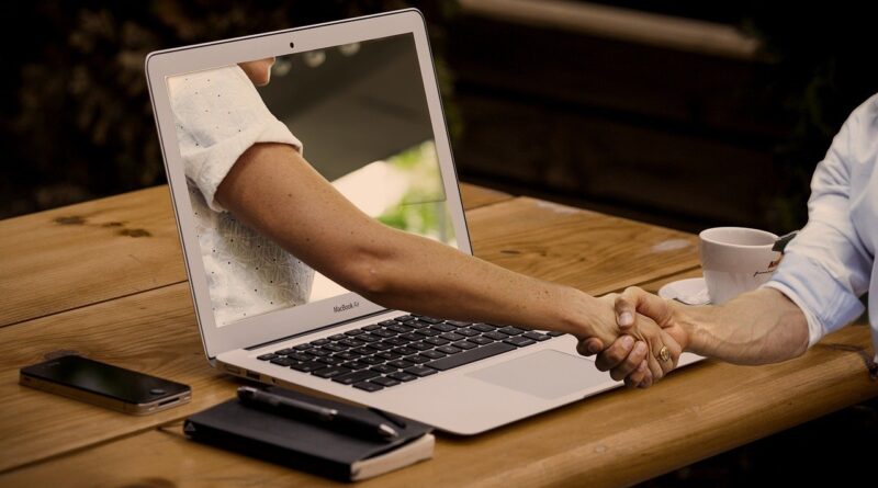 people shaking hands through a computer screen