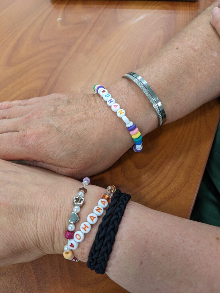Picture 15 - The spirit of ʻOhana; Photo credit: Shannon Donnally Quinn - two people wearing bracelets that say Ohana