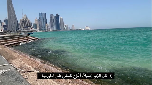 Picture 2 - This is Doha’s scenic Corniche, known for its waterfront promenade that juxtaposes the city’s historic dhow (traditional wooden boat) harbor. It’s a space for recreation and community life. Subtitle translation: “If the weather is nice, I go out for a walk on the corniche.”