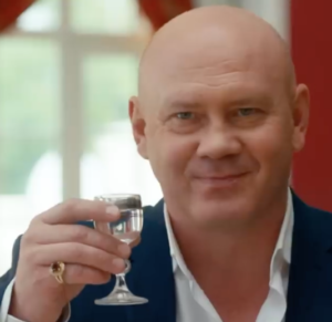 a bald man toasting with vodka